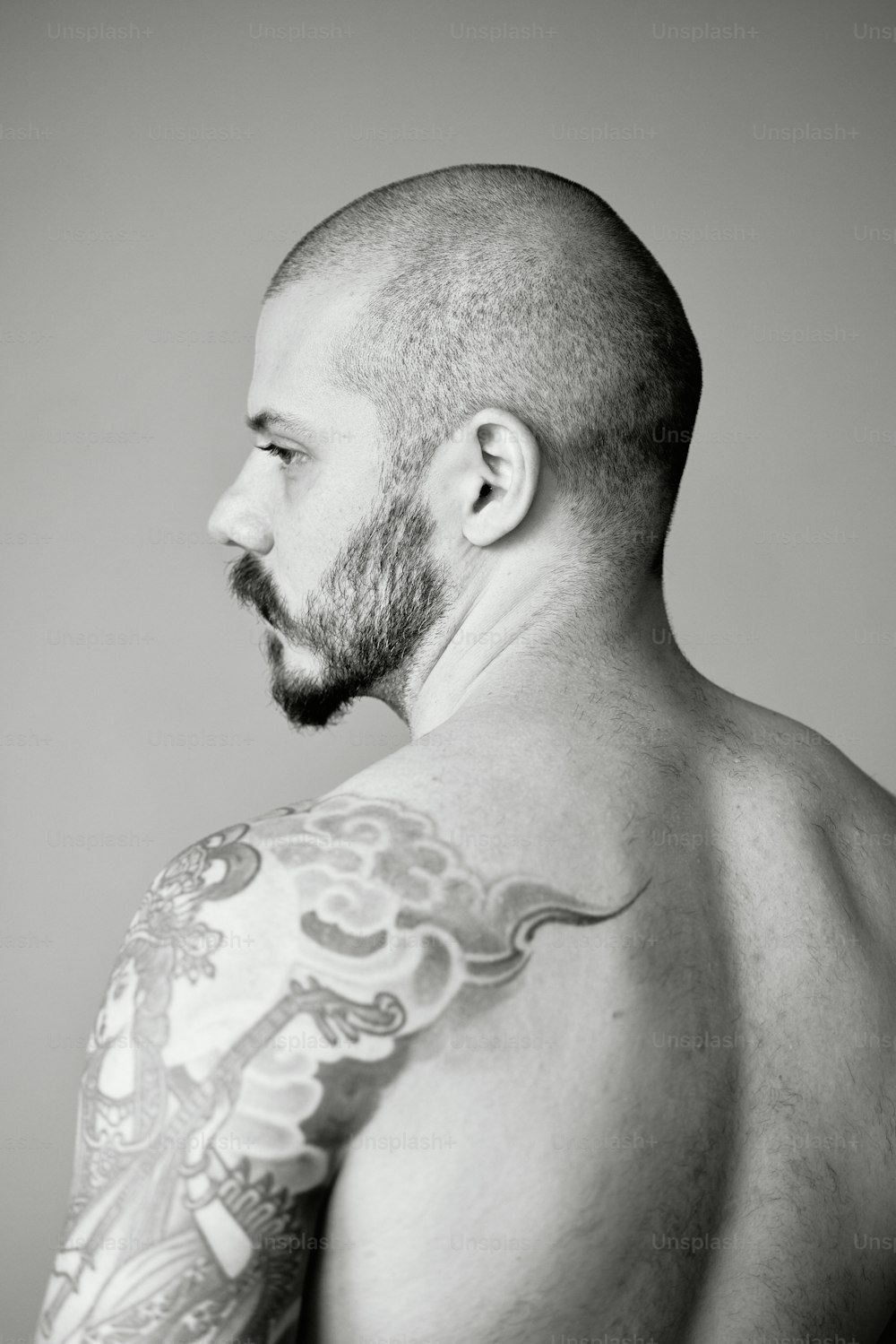 a man with a beard and tattoos on his chest
