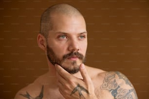 a man with a goatee and tattoos on his chest