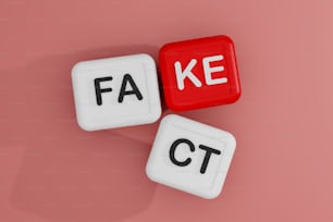 two dices with the words fa, ke and ct on them