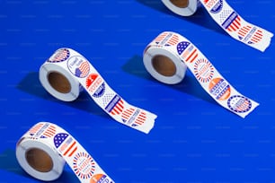 three rolls of patriotic stickers on a blue background