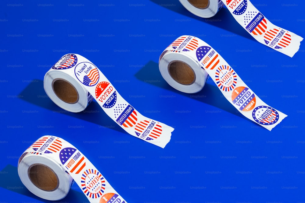 three rolls of patriotic stickers on a blue background