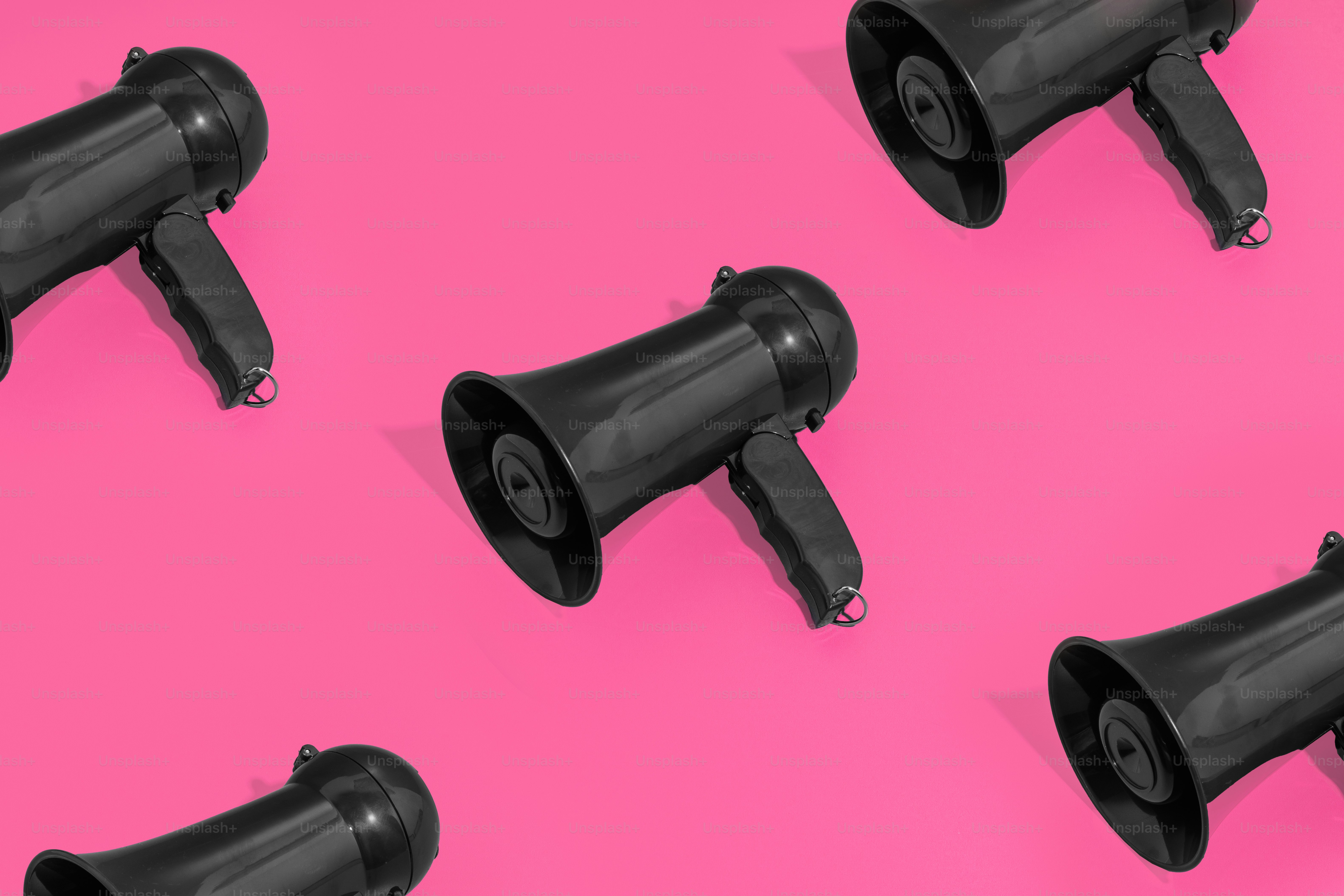 un gruppo di altoparlanti neri seduti sopra una superficie rosa
