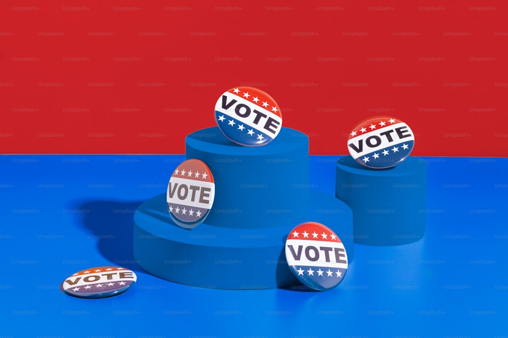 un grupo de botones políticos sentados en lo alto de un pedestal azul