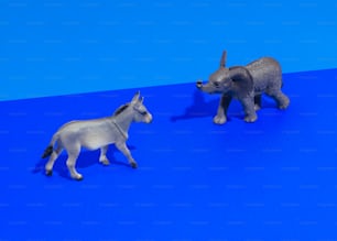 um par de animais de brinquedo em cima de uma superfície azul