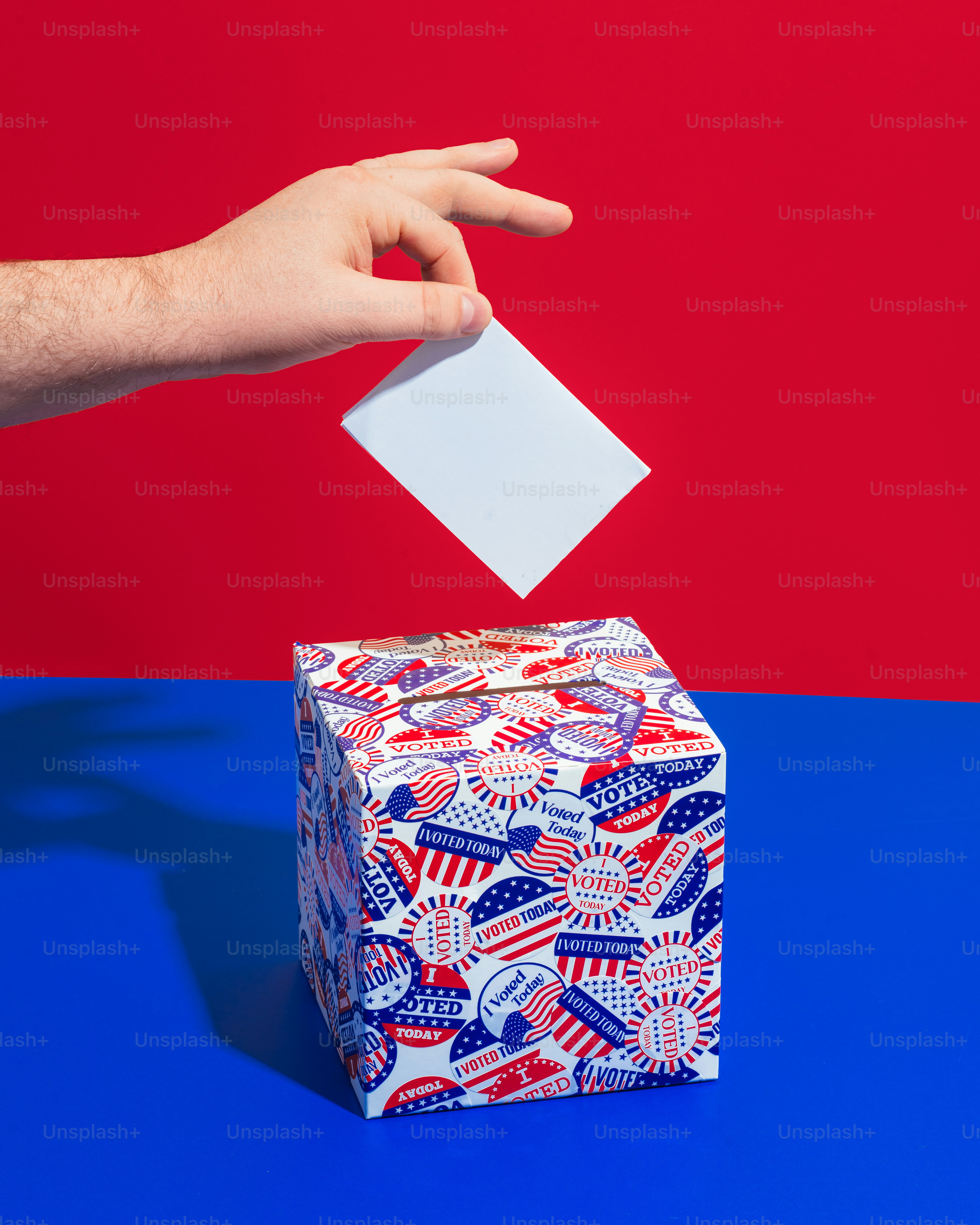 a person's hand throwing a piece of paper into a gift box