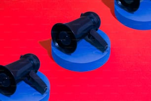 a couple of black speakers sitting on top of a blue stand