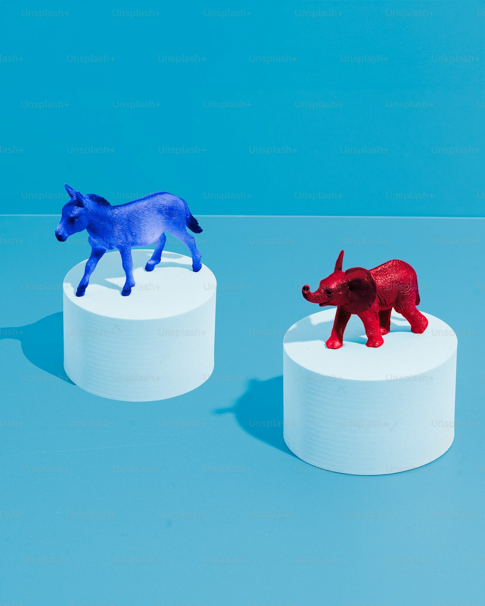 um par de pequenos animais de plástico sentados em cima de uma mesa