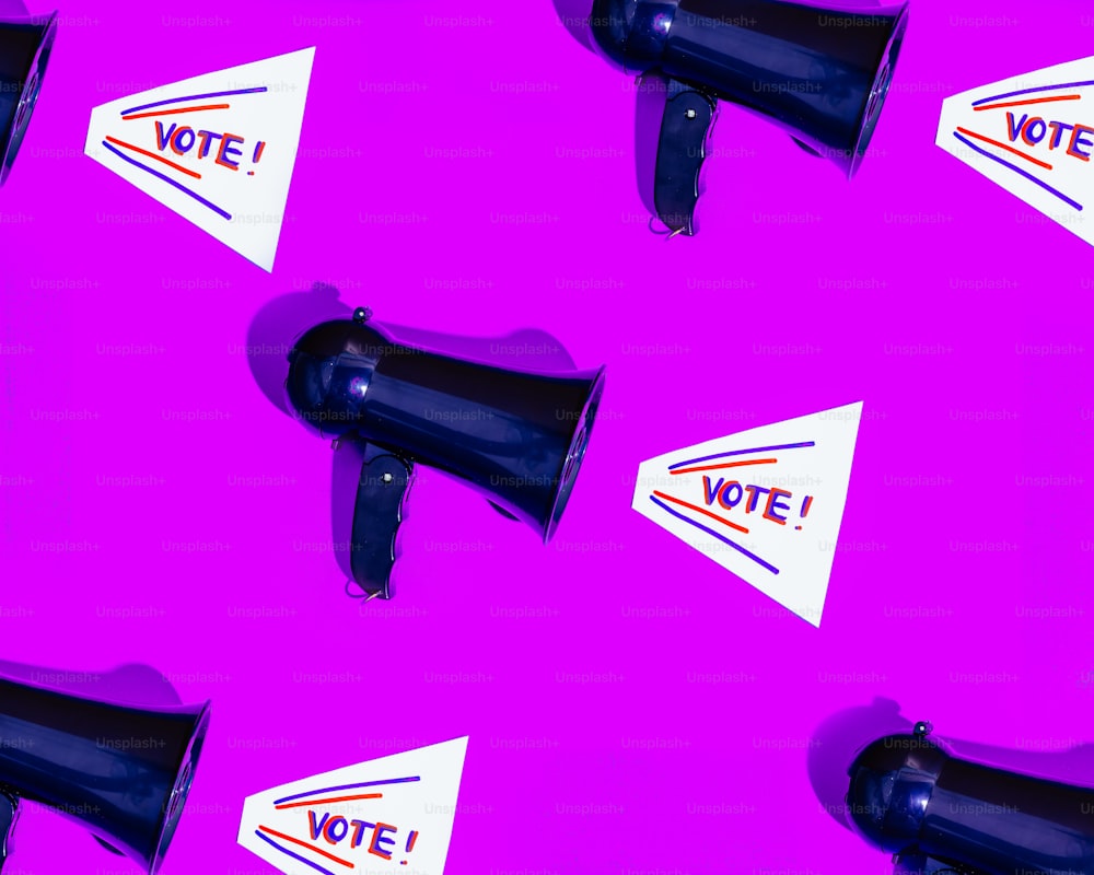 a group of black megaphones sitting on top of a pink wall