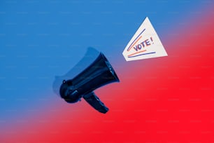 a black megaphone with a vote sticker on it