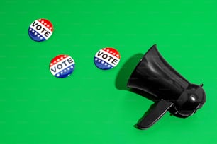 a black megaphone and three red, white and blue buttons