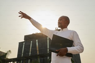 a man holding a binder in front of a building