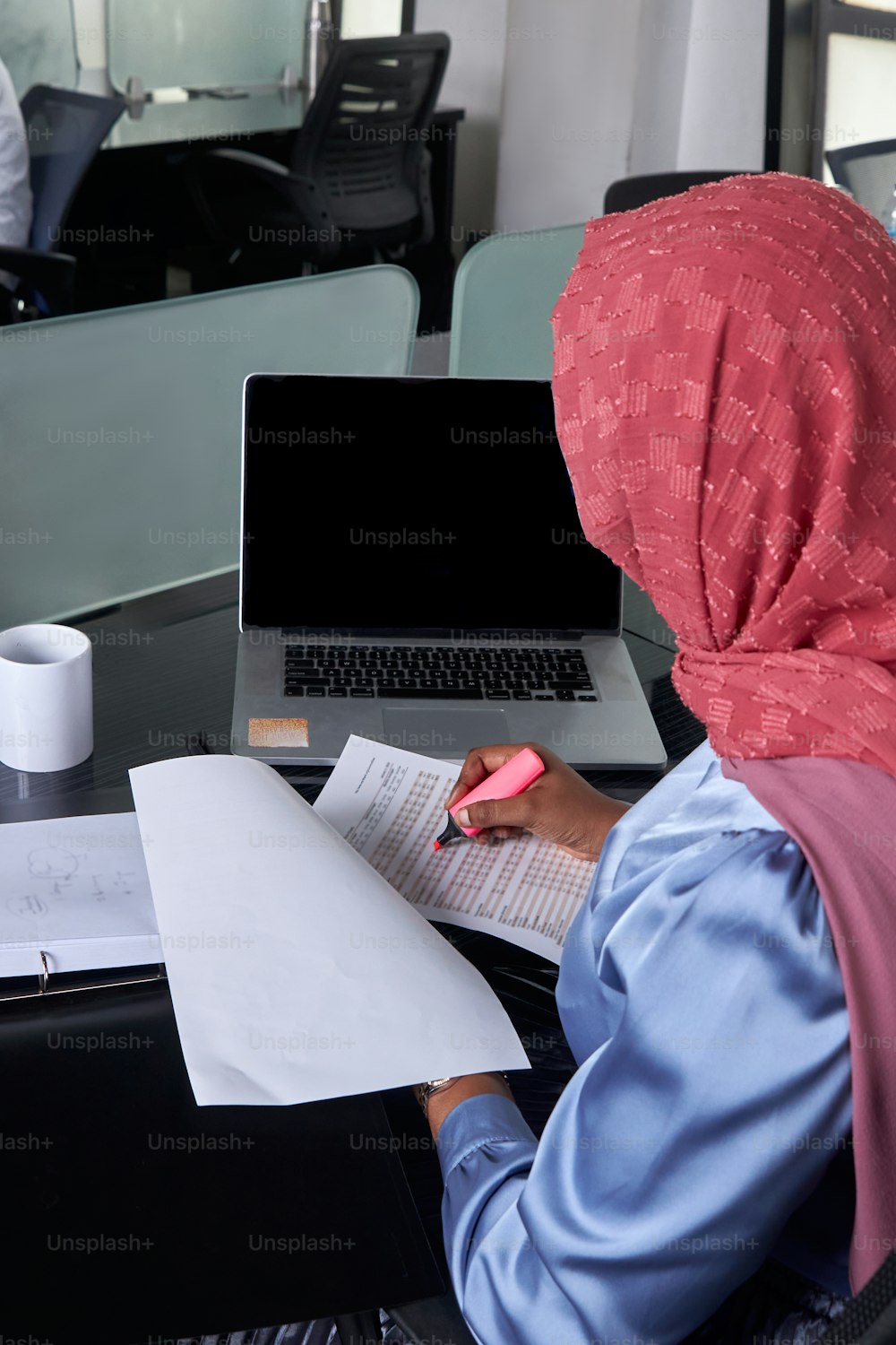 a woman sitting at a desk with a laptop computer