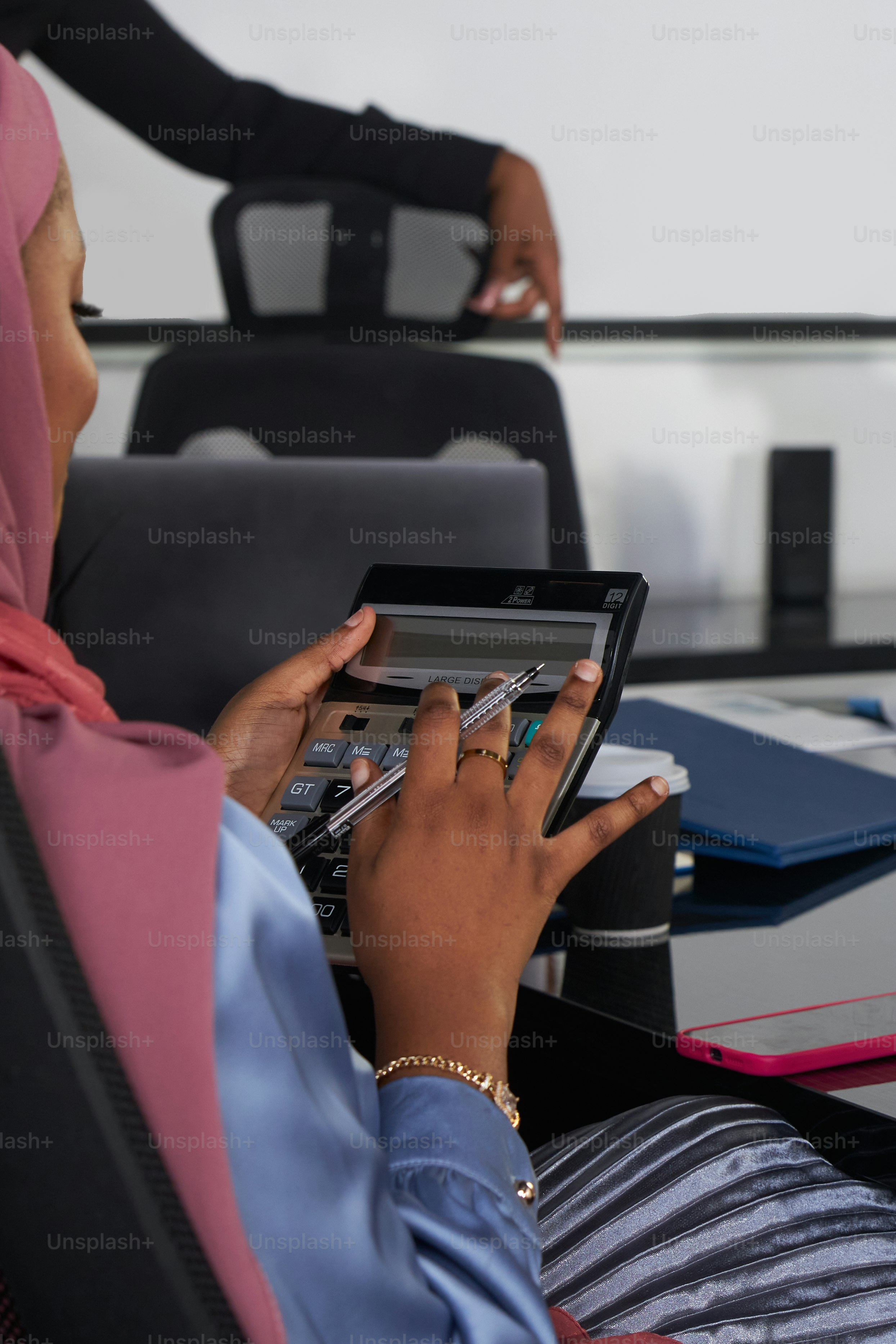 eine Frau, die an einem Schreibtisch sitzt und einen Tablet-Computer benutzt