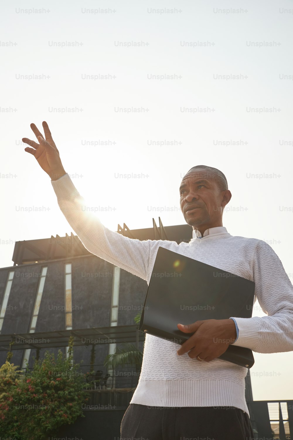 a man in a white shirt holding a black folder