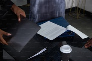 a person sitting at a desk with a book and a coffee cup