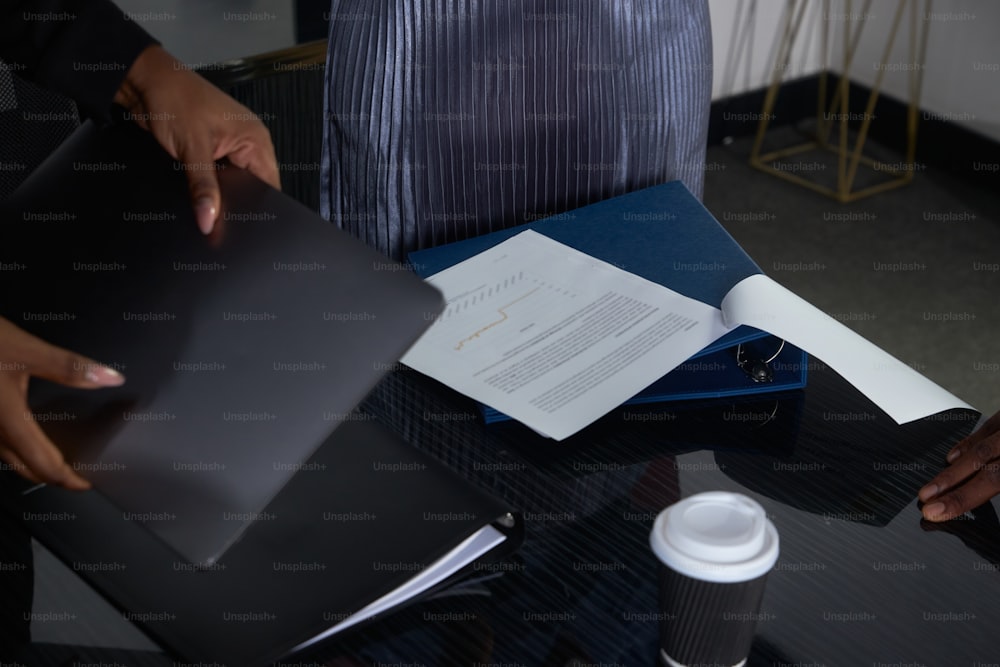 una persona seduta a una scrivania con un libro e una tazza di caffè