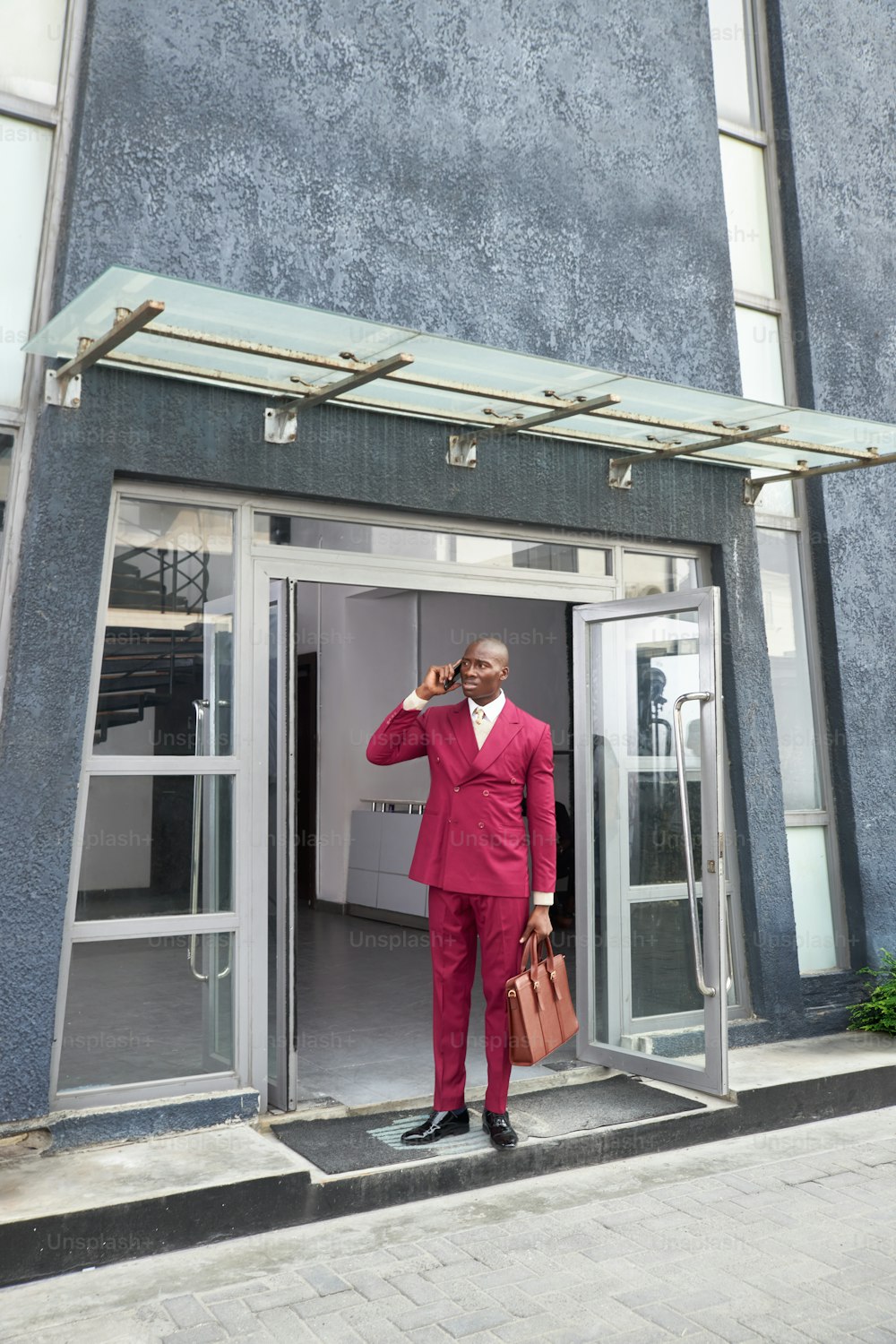 a man in a red suit standing in a doorway