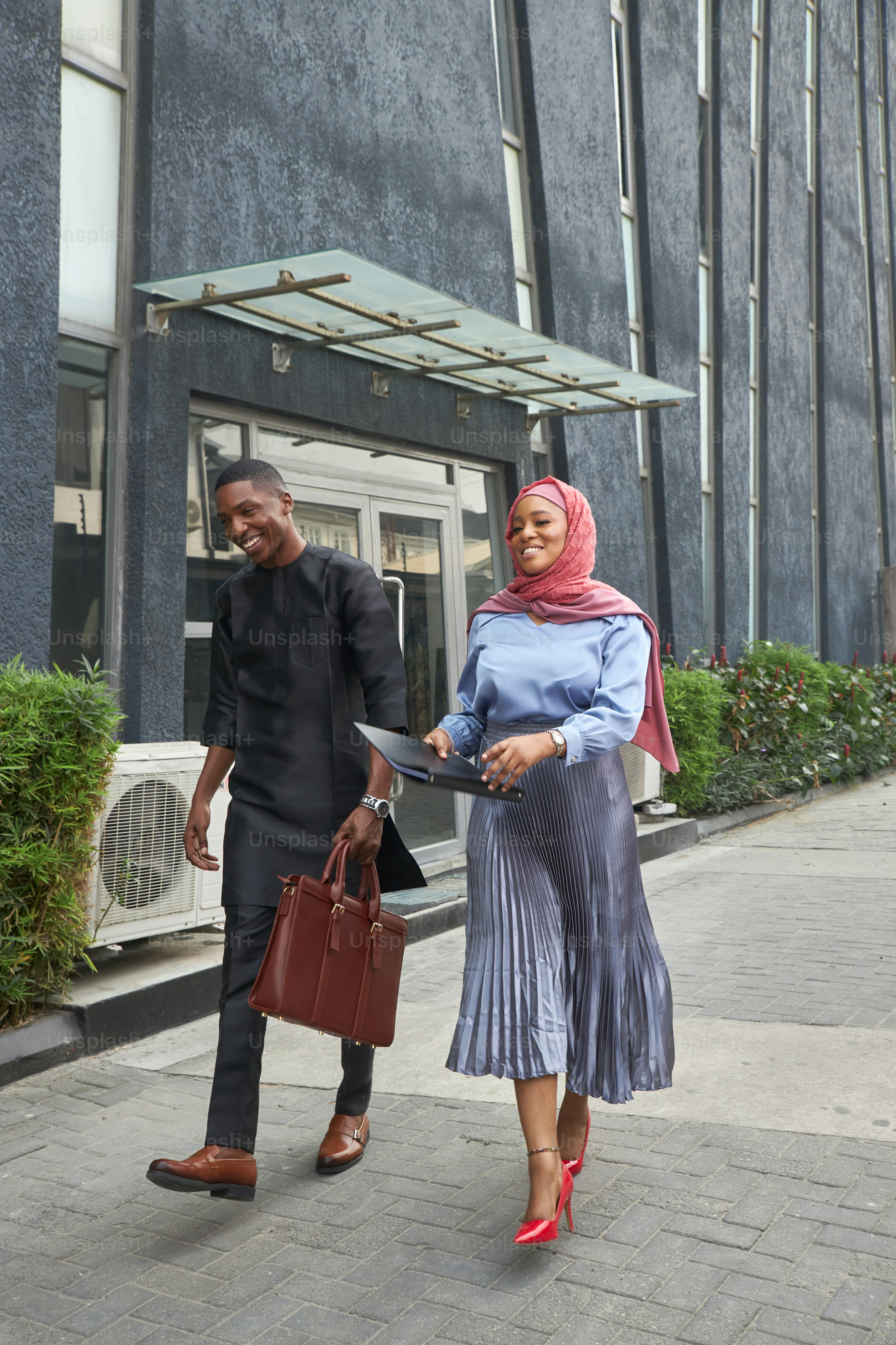 a man and a woman walking down a sidewalk