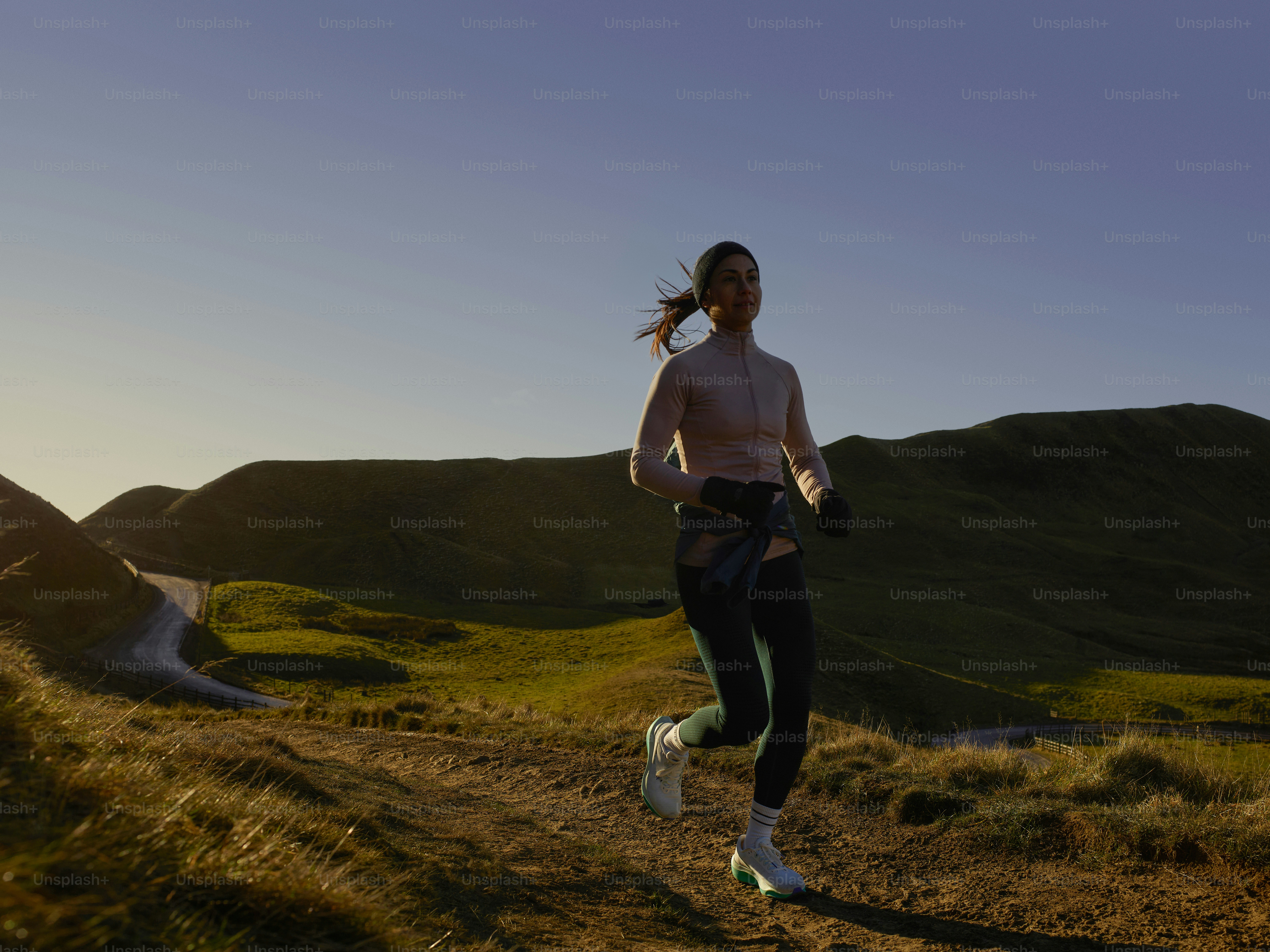 a woman running on a trail in the mountains