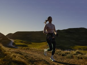 a woman running on a trail in the mountains