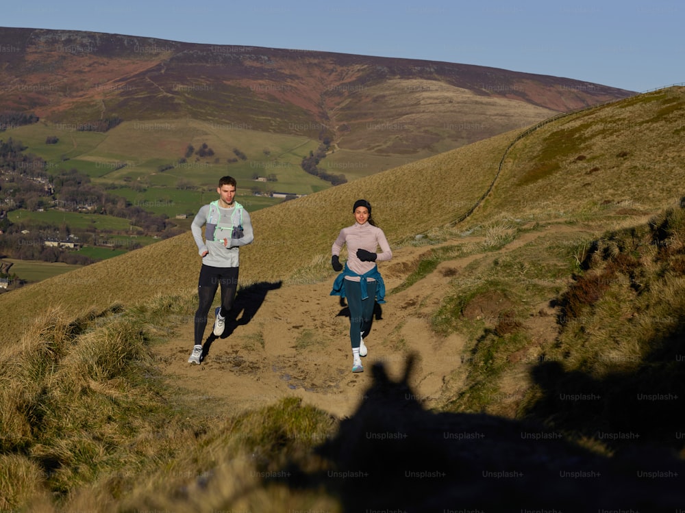 a couple of people that are running down a hill