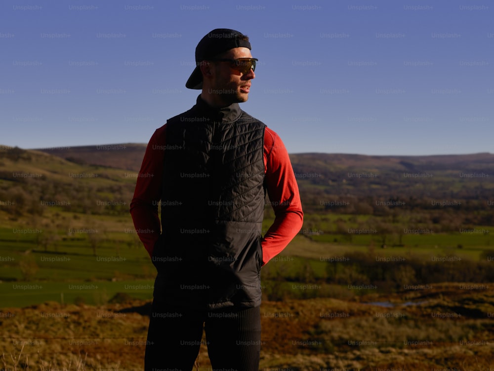 a man standing on top of a lush green hillside