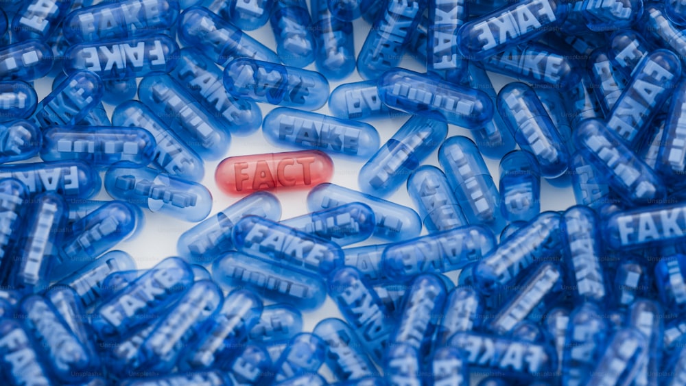 a red pill pill sitting on top of a pile of blue pills
