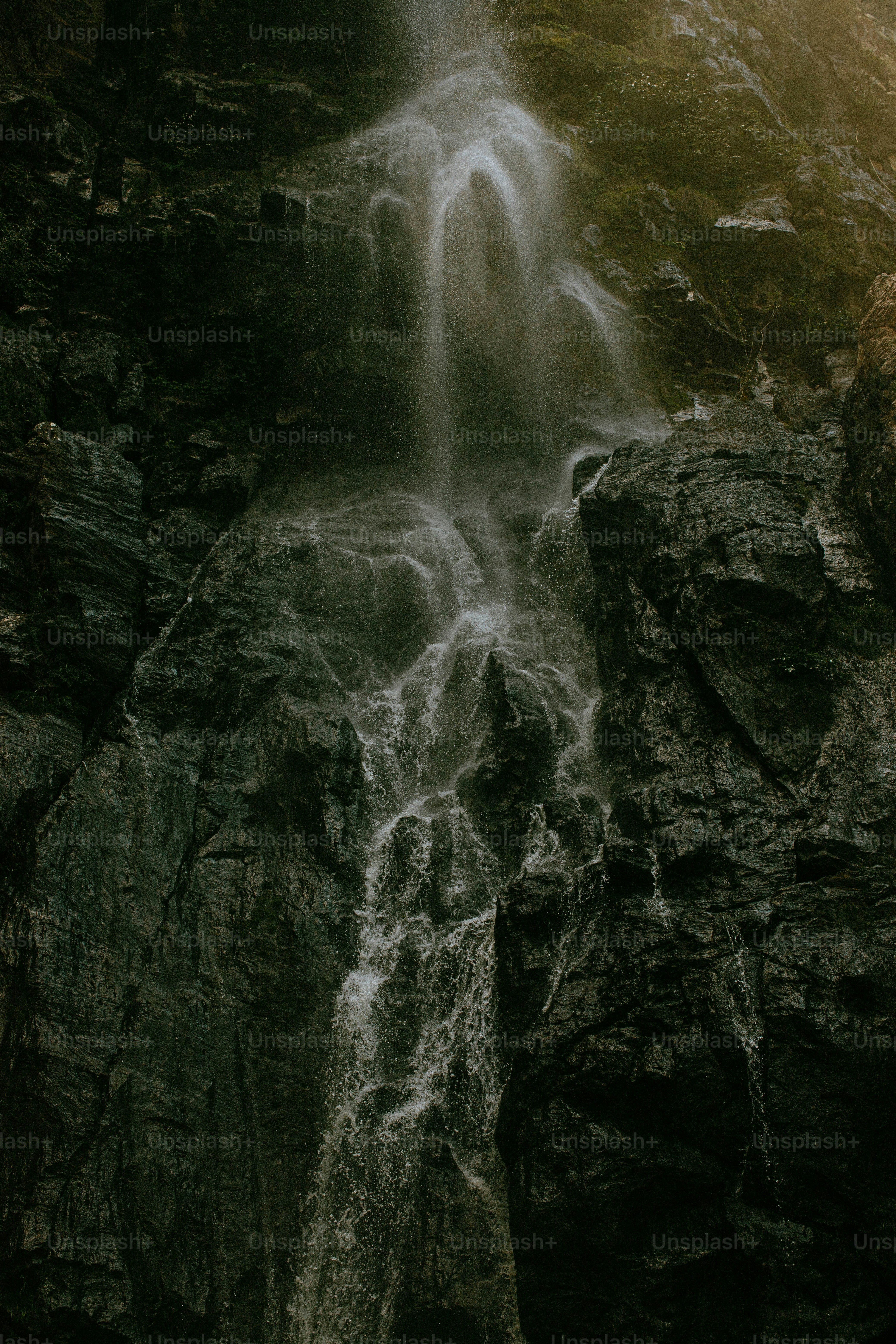 a waterfall with a man standing in front of it
