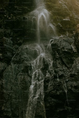 a waterfall with a man standing in front of it