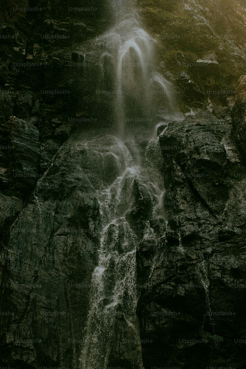 a waterfall with a man standing in front of it