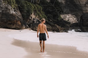 海辺の浜辺を歩く男性