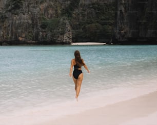 uma mulher de biquíni correndo na praia