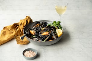 a bowl of mussels and a glass of wine