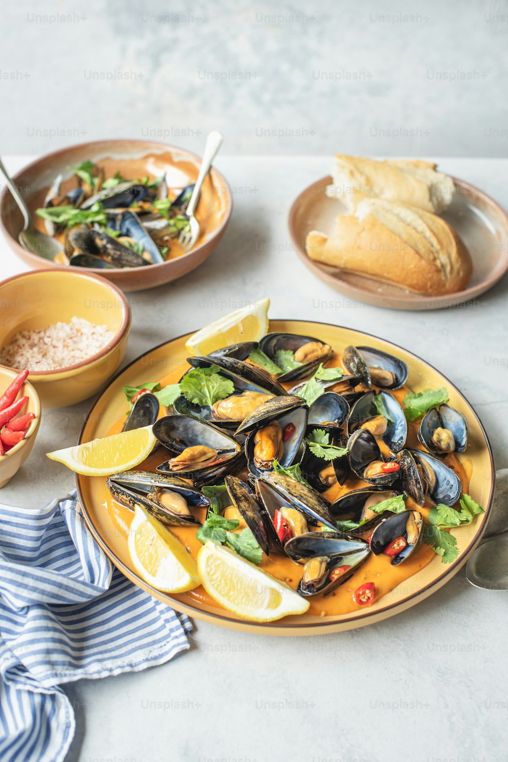 a plate of mussels and a bowl of bread