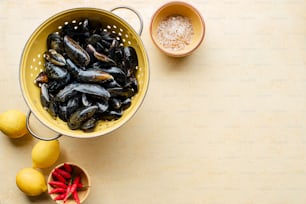 a bowl of mussels next to a bowl of lemons