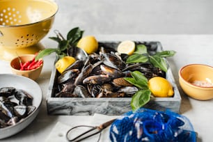 a plate of mussels and a bowl of lemons