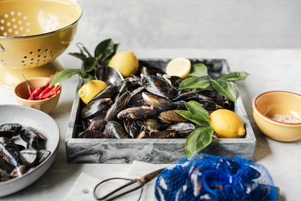 a plate of mussels and a bowl of lemons