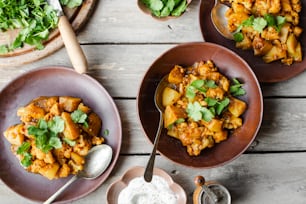 three plates of food on a table with spoons