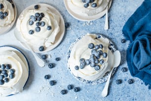a table topped with cakes covered in frosting and blueberries
