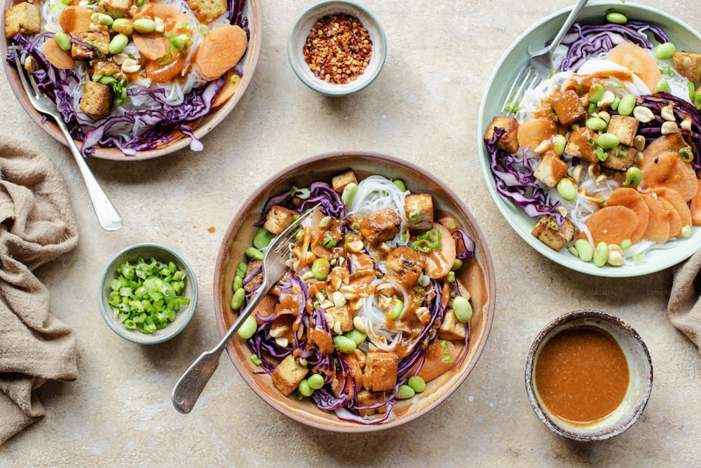 a table topped with plates of food and bowls of sauce