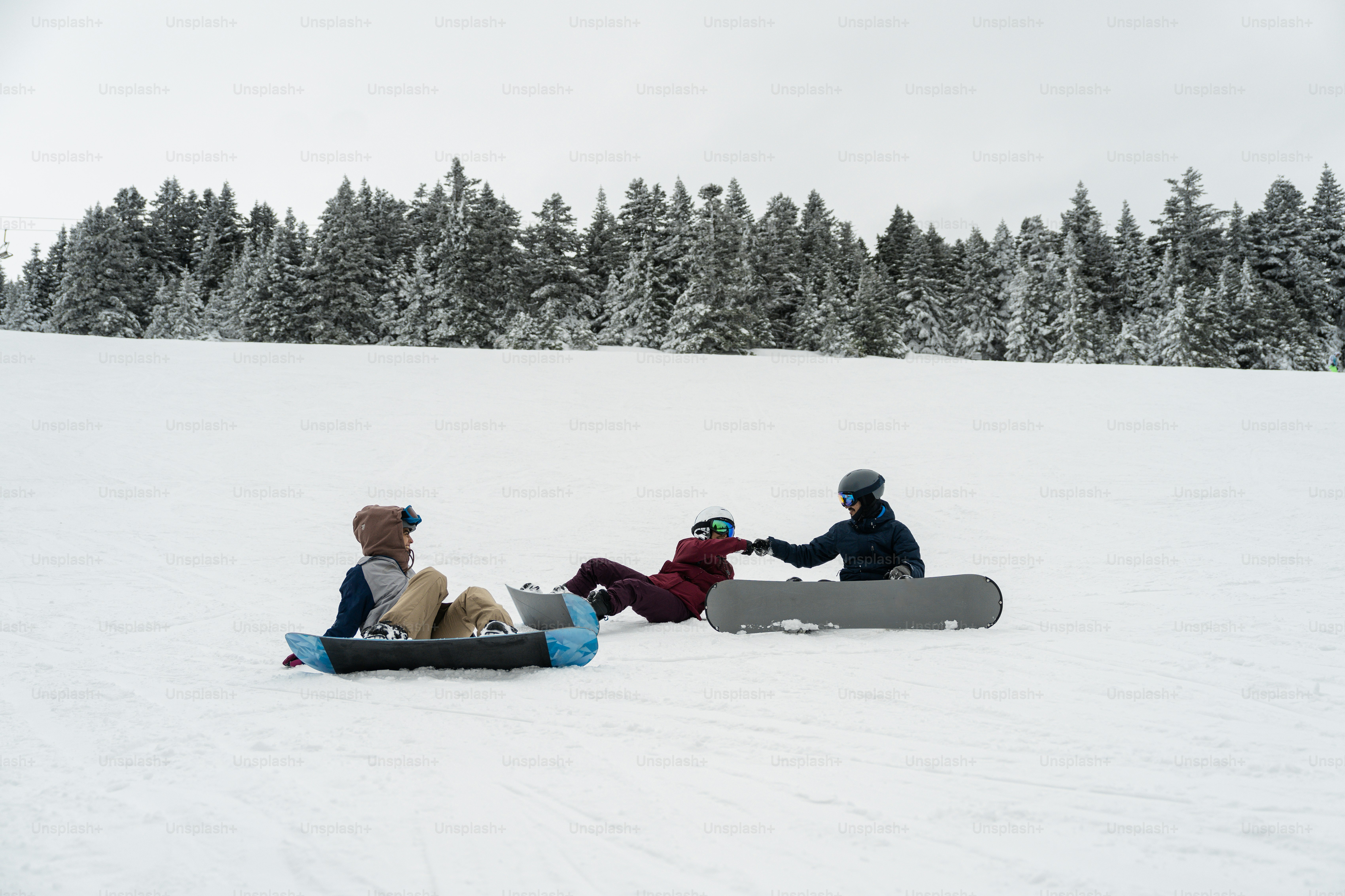Eine Gruppe von Menschen, die auf einem schneebedeckten Hang sitzen