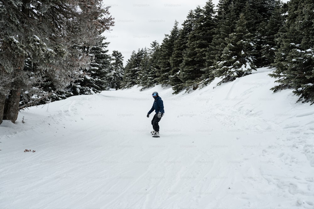 a man riding a snowboard down a snow covered slope