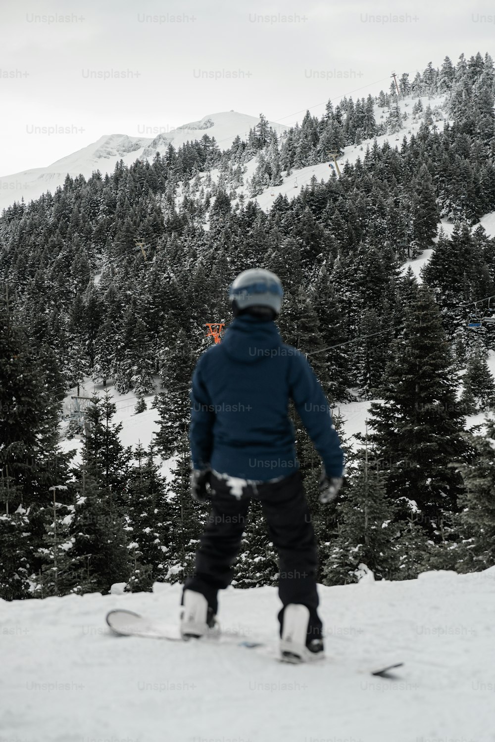 a person riding a snowboard down a snow covered slope