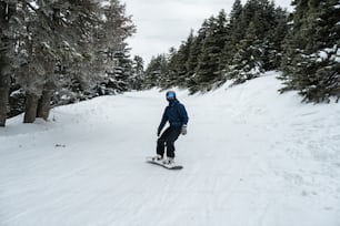 a man riding a snowboard down a snow covered slope