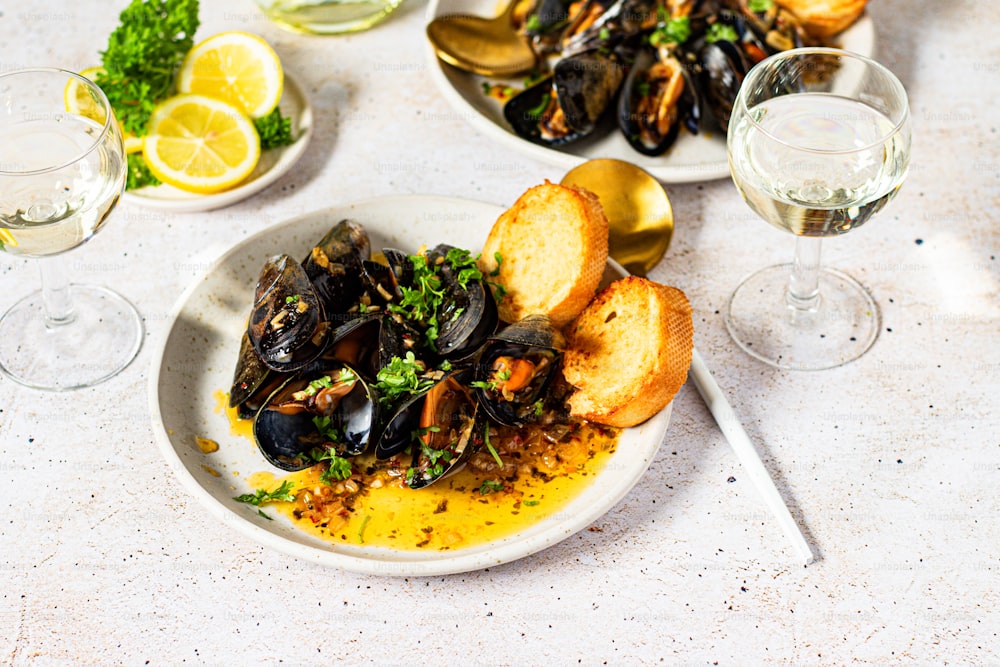 a plate of mussels and bread on a table
