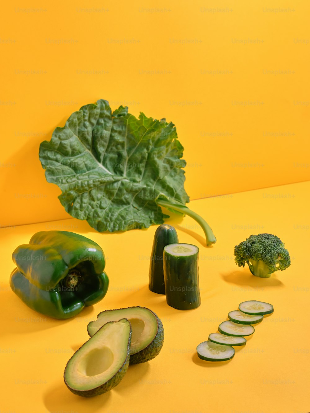 a group of vegetables sitting on top of a yellow table
