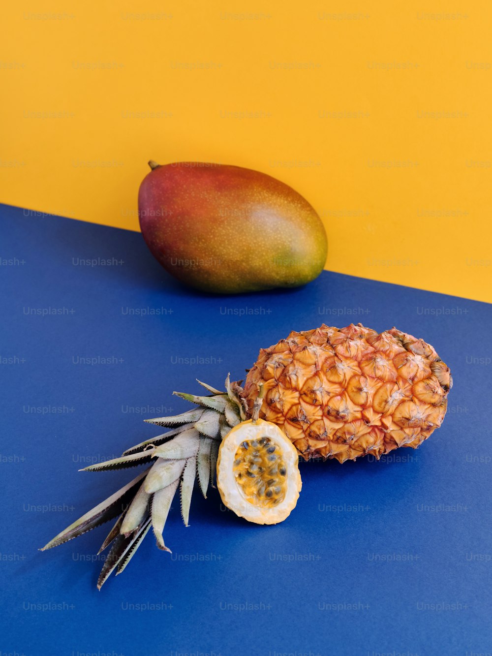 a pineapple and a mango on a blue table