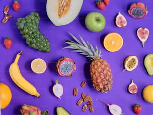 a variety of fruits are arranged on a purple surface