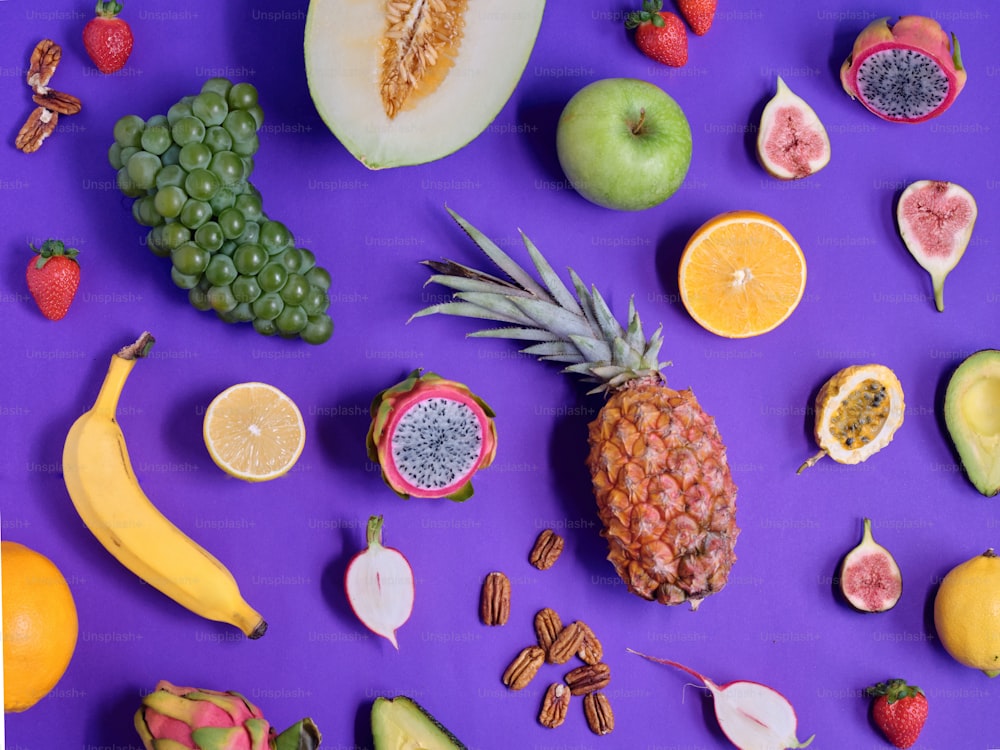 Eine Vielzahl von Früchten ist auf einer violetten Fläche angeordnet