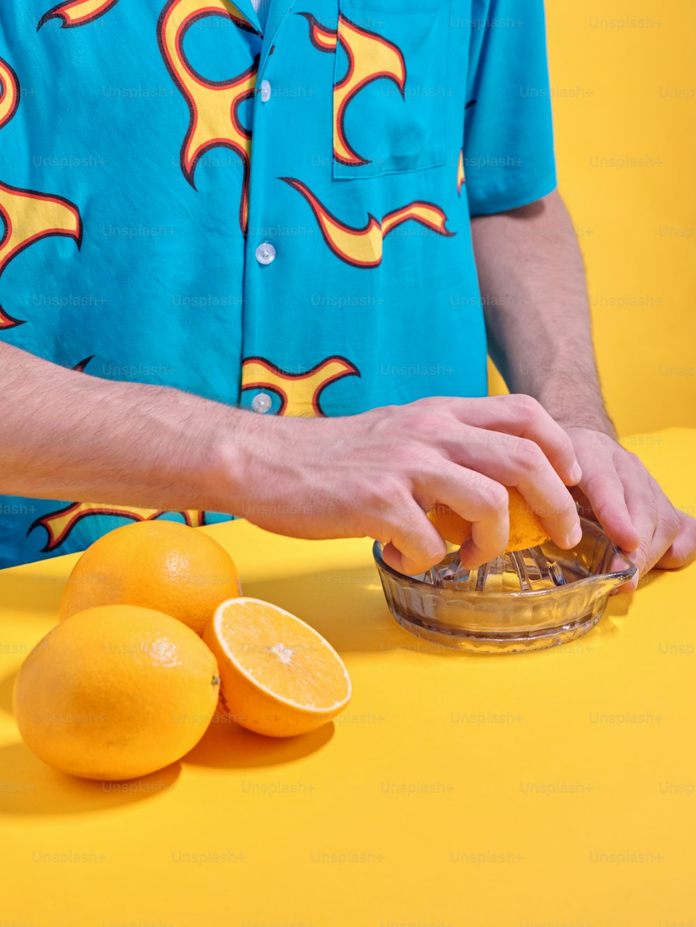 a man in a blue shirt is peeling an orange